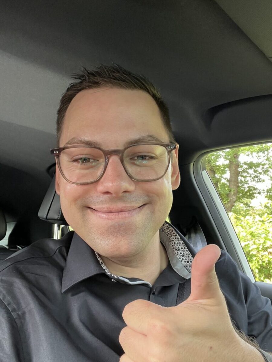 Sebastian Selle lachend im Auto, Daumen nach oben